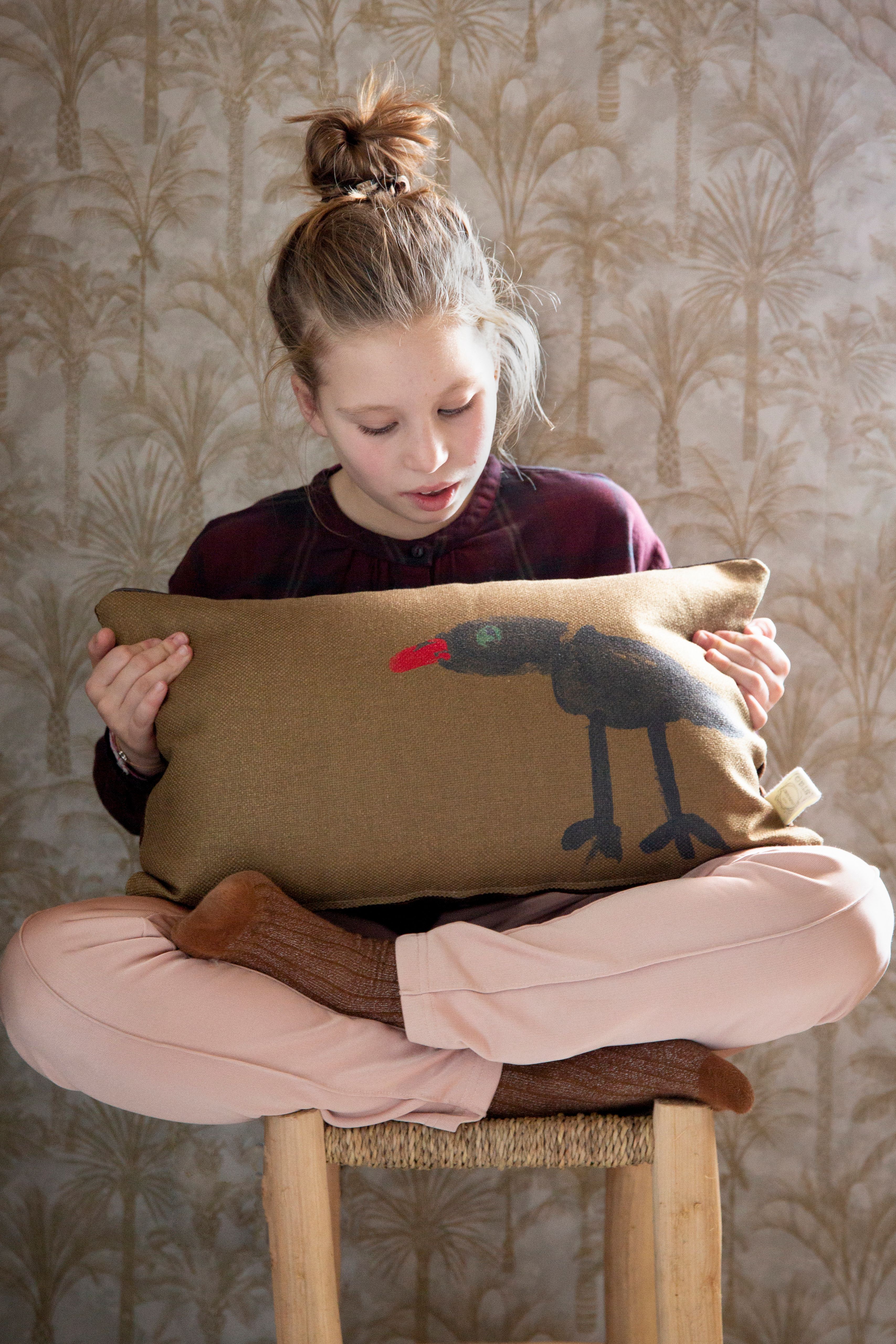 Kind in kleermakerzit met kussen in hand
