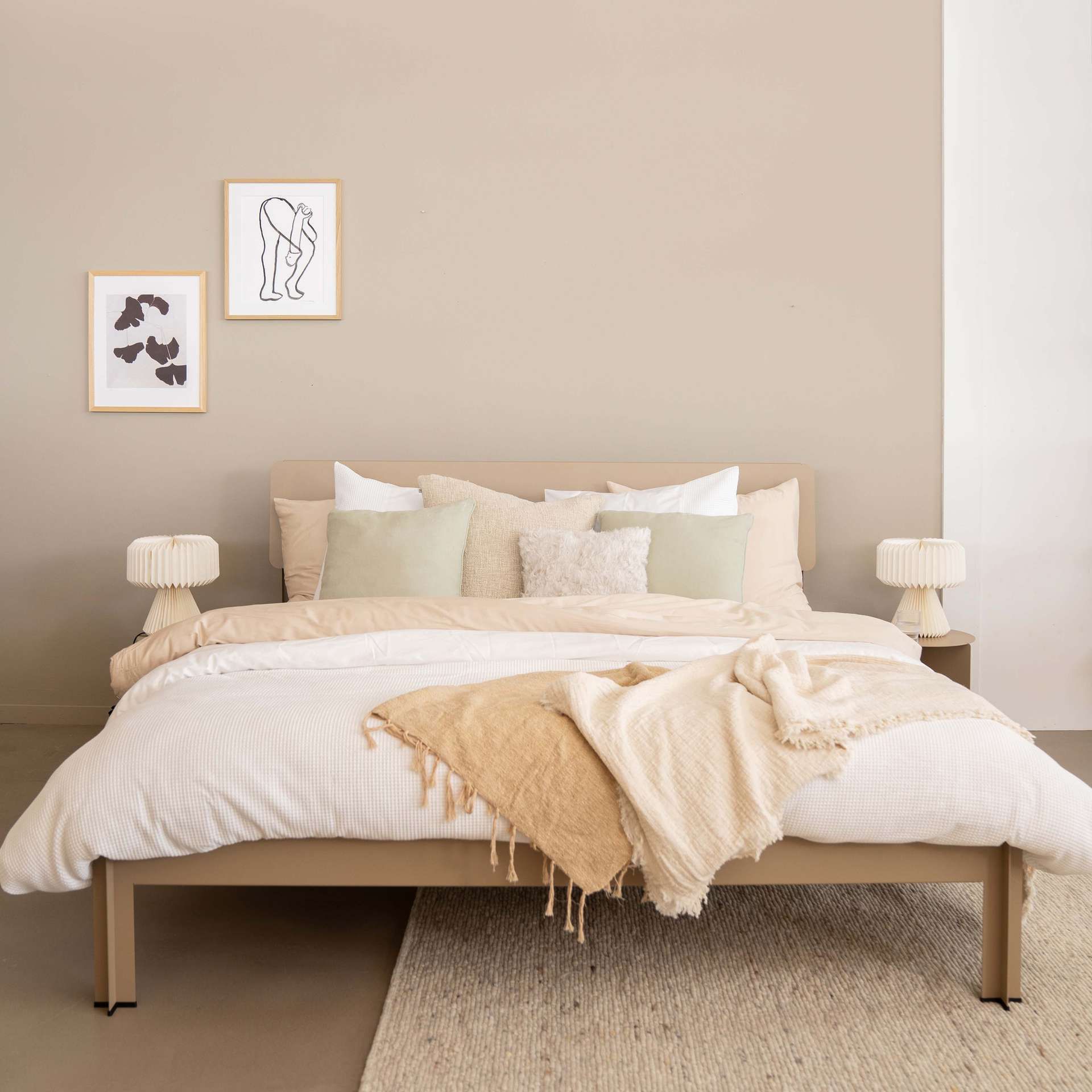 Opgemaakt bed met lichte natuurlijke kleuren