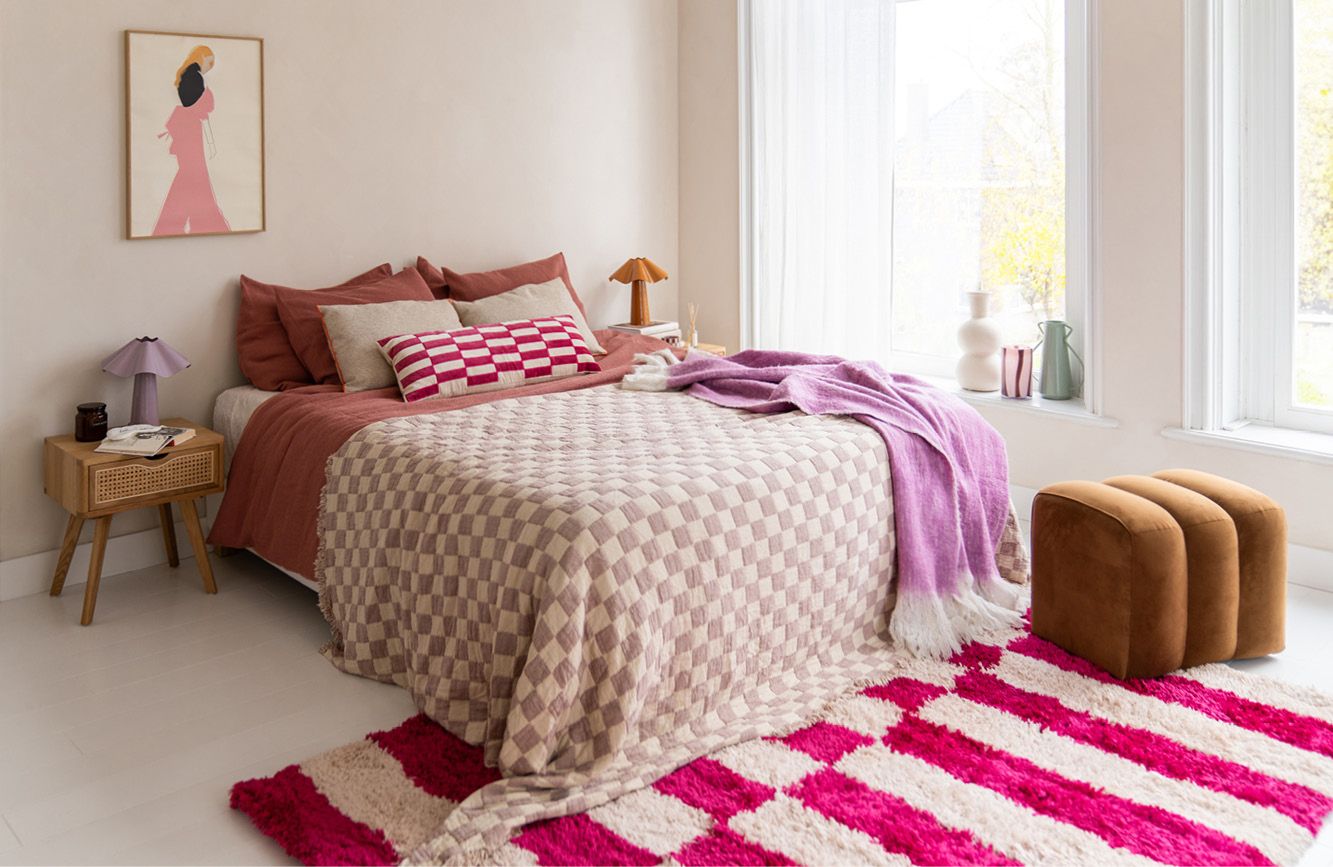 Kleurrijk opgemaakt bed roze tinten en blokjes