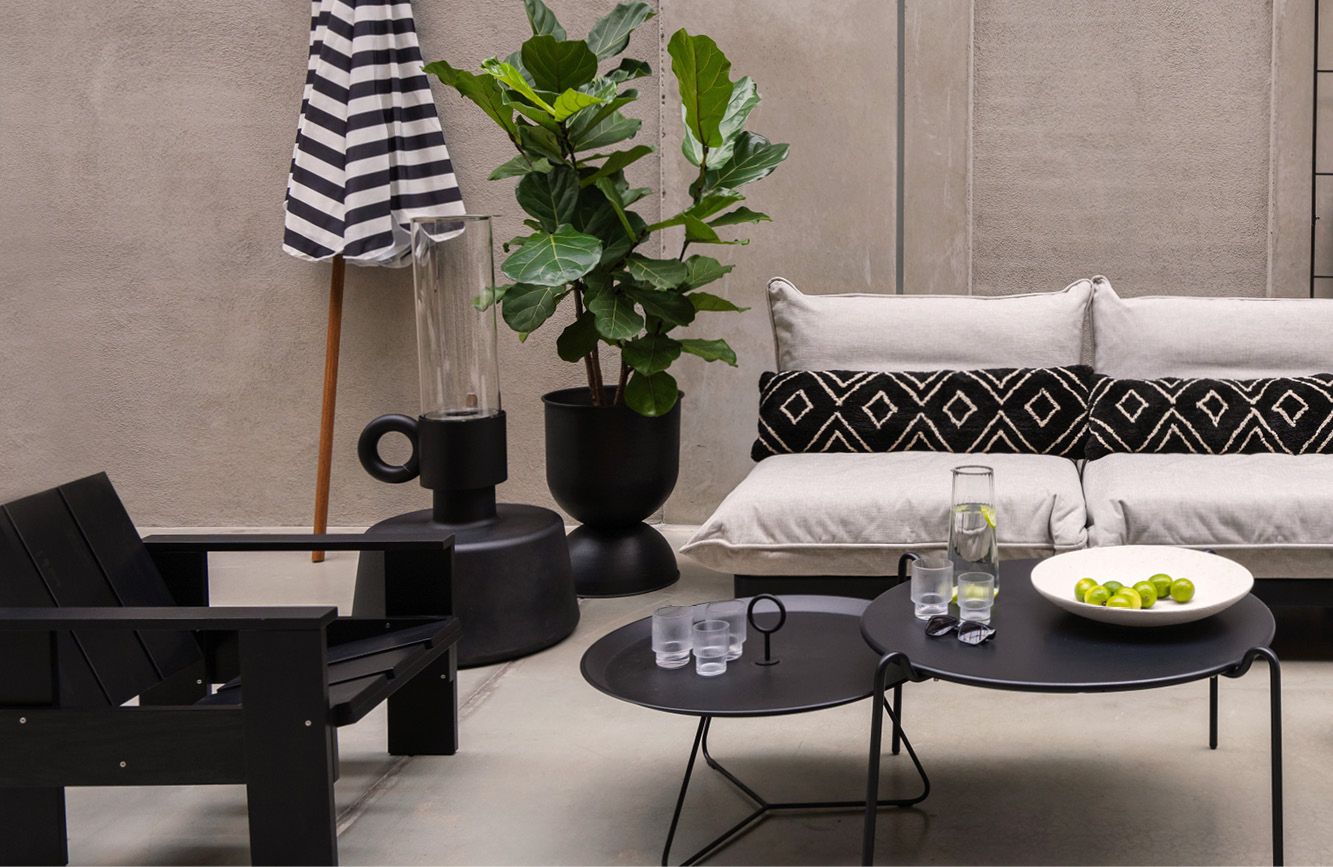 Buitenlounge setting met grote zwarte buiten vloerlamp