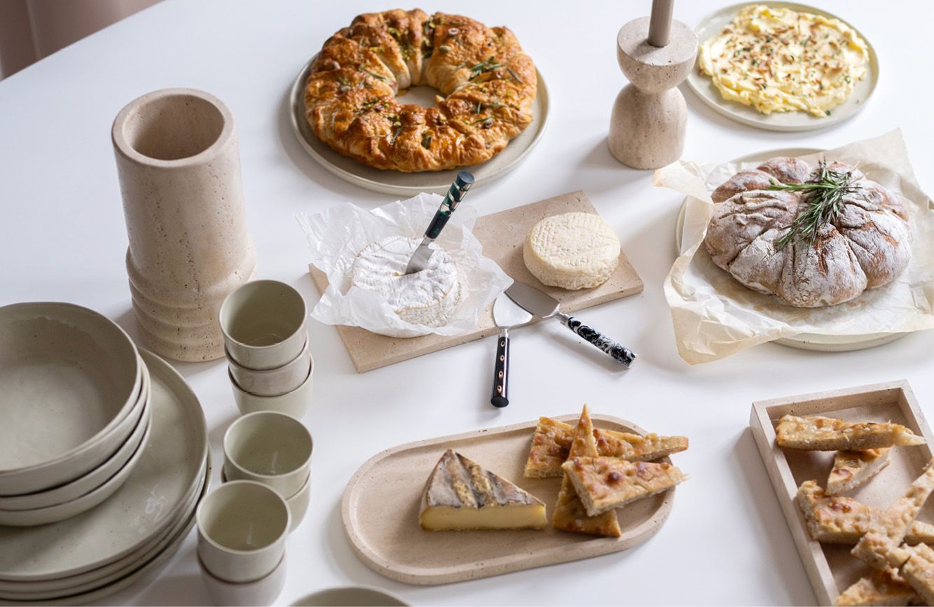 Tafel vol met serveerplanken en servies en eten
