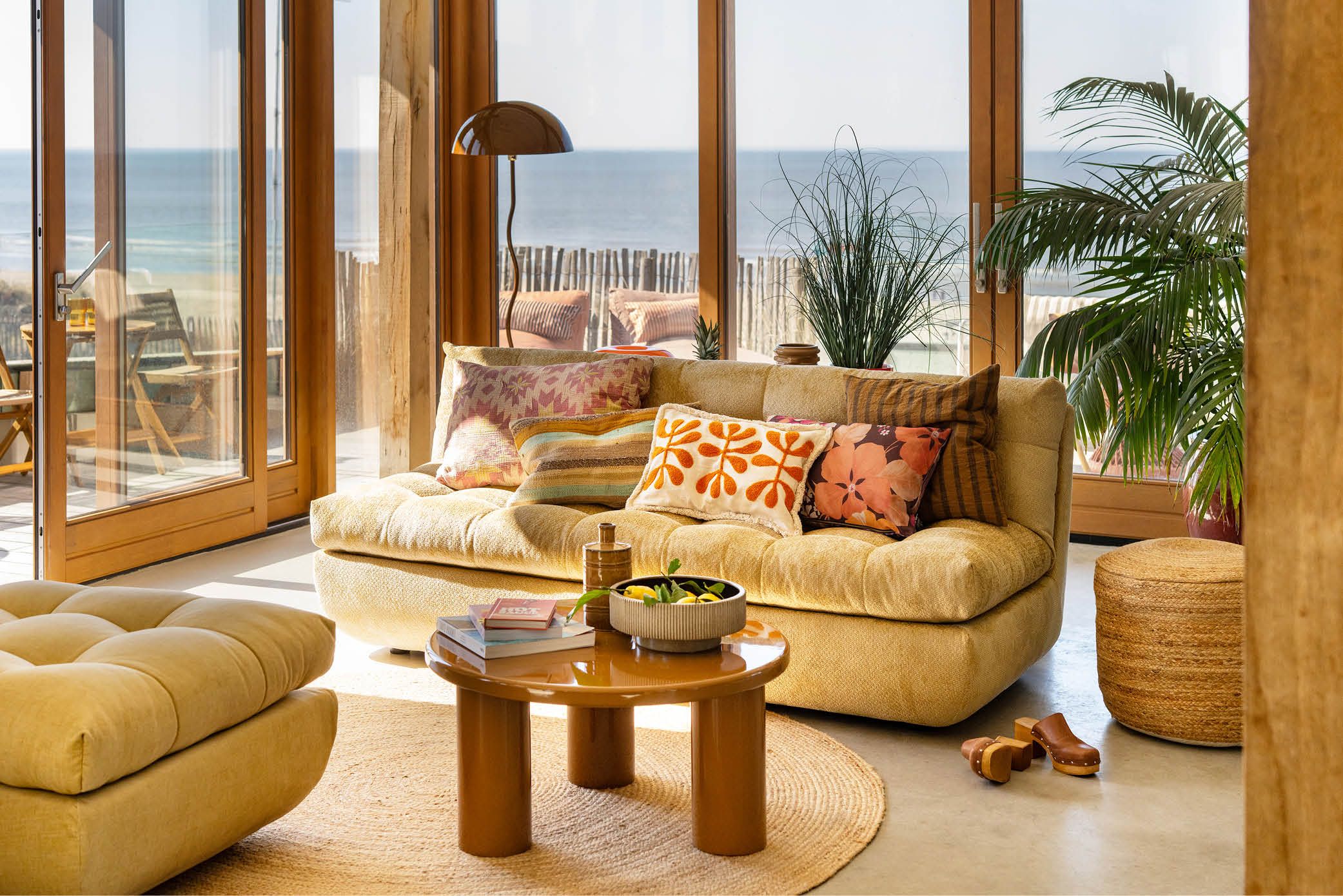 Zonnige woonkamer aan het strand met gele bank en vrolijke accessoires