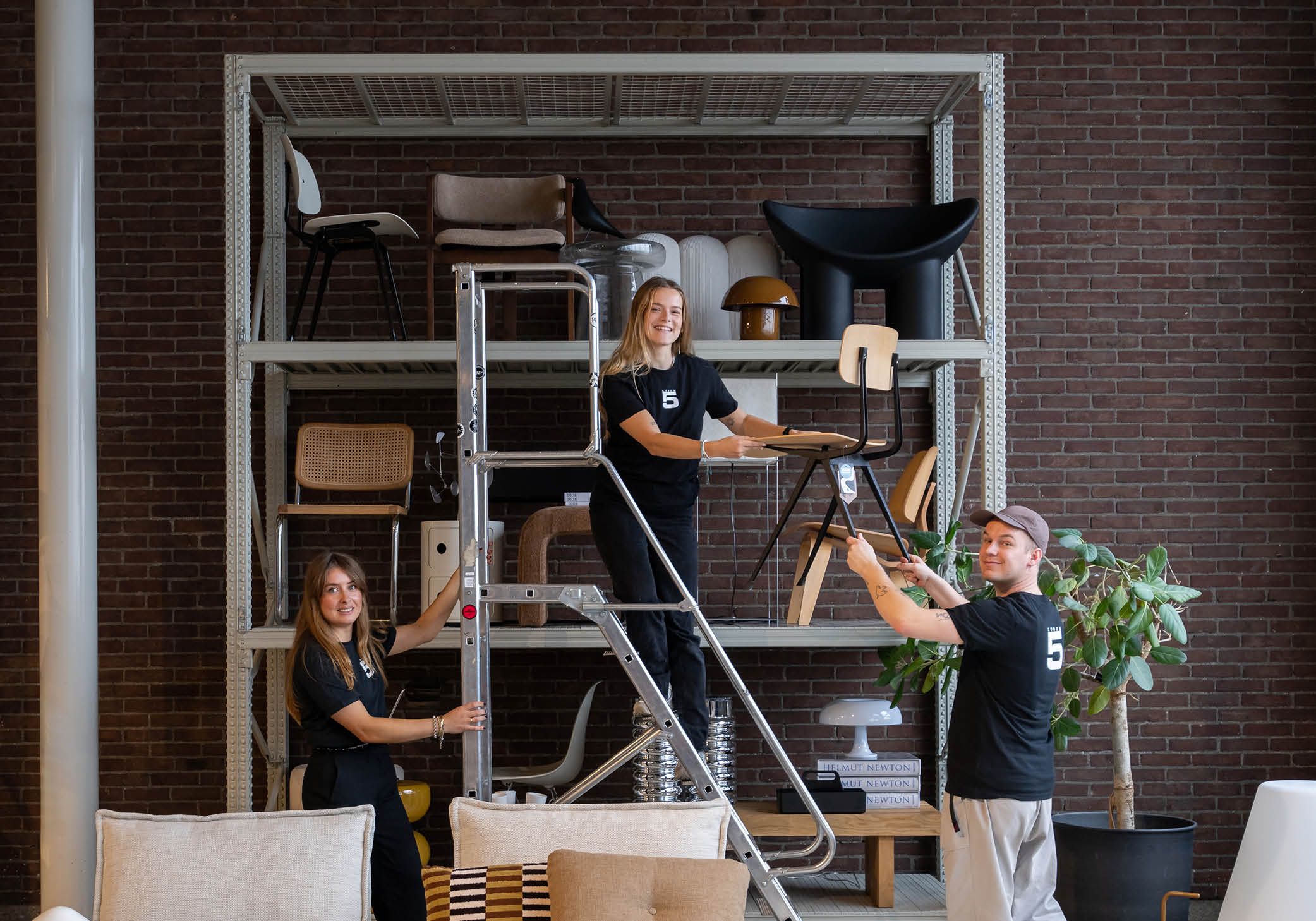 Loods 5 kar met accessoires en 3 werknemers die spullen tillen