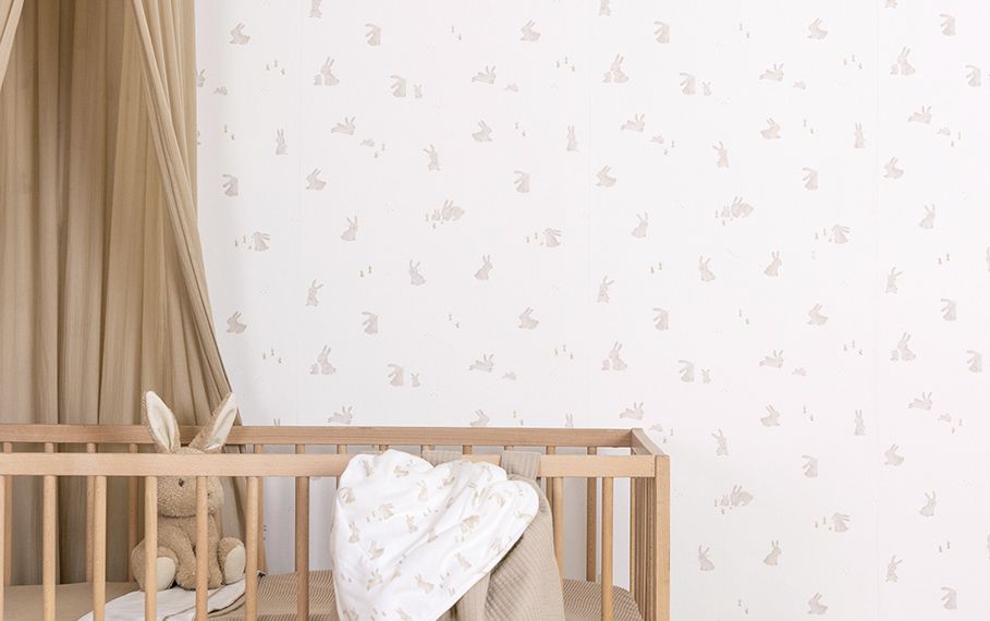 Wit behang met konijntjes op een kinderkamer