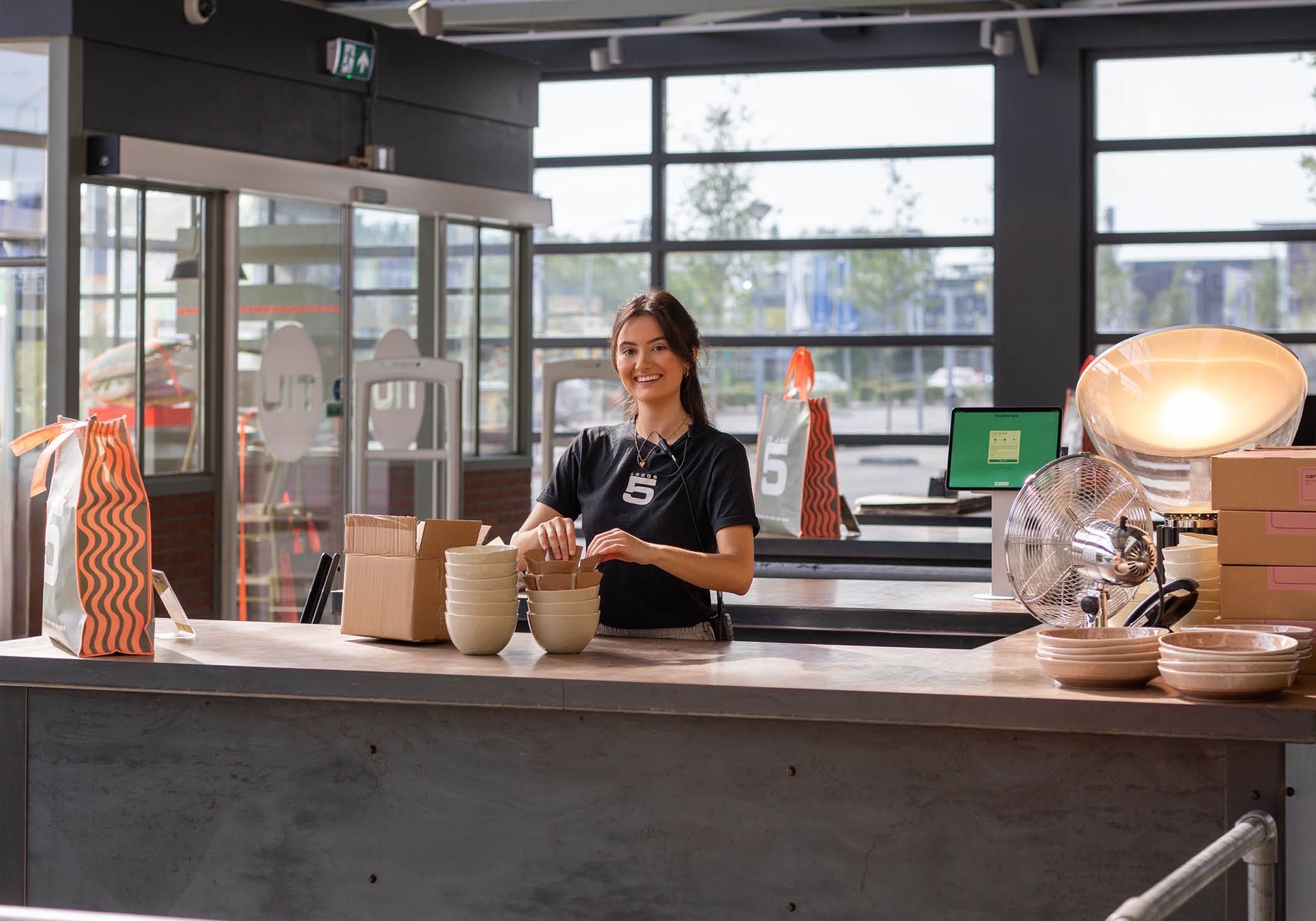 Loods 5 winkelmedewerker achter de kassa in Loods 5 winkel