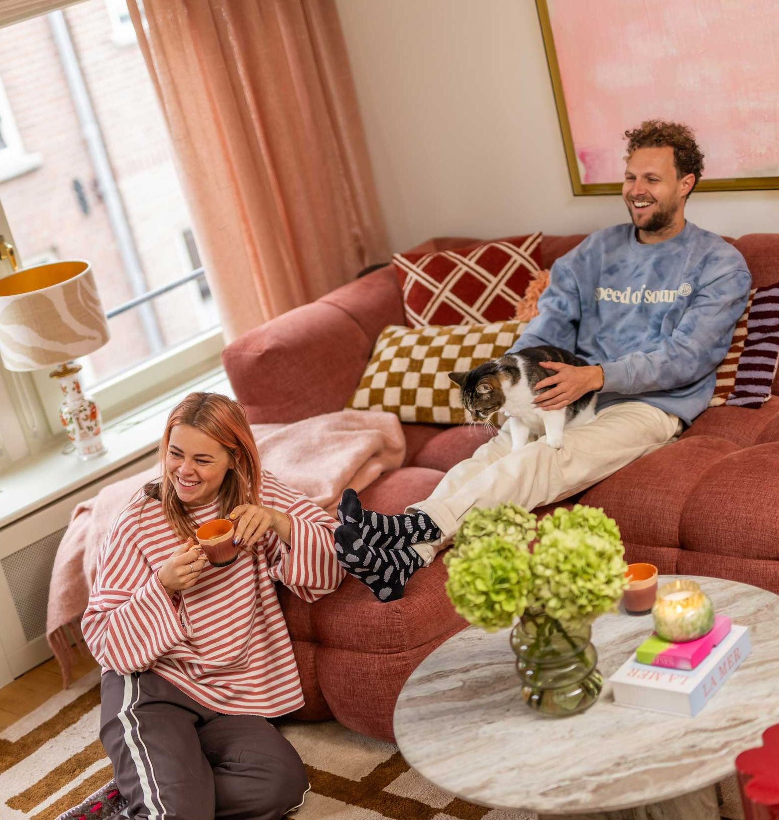 Vrouw en man op de bank in een gezellige kleurrijke woonkamer