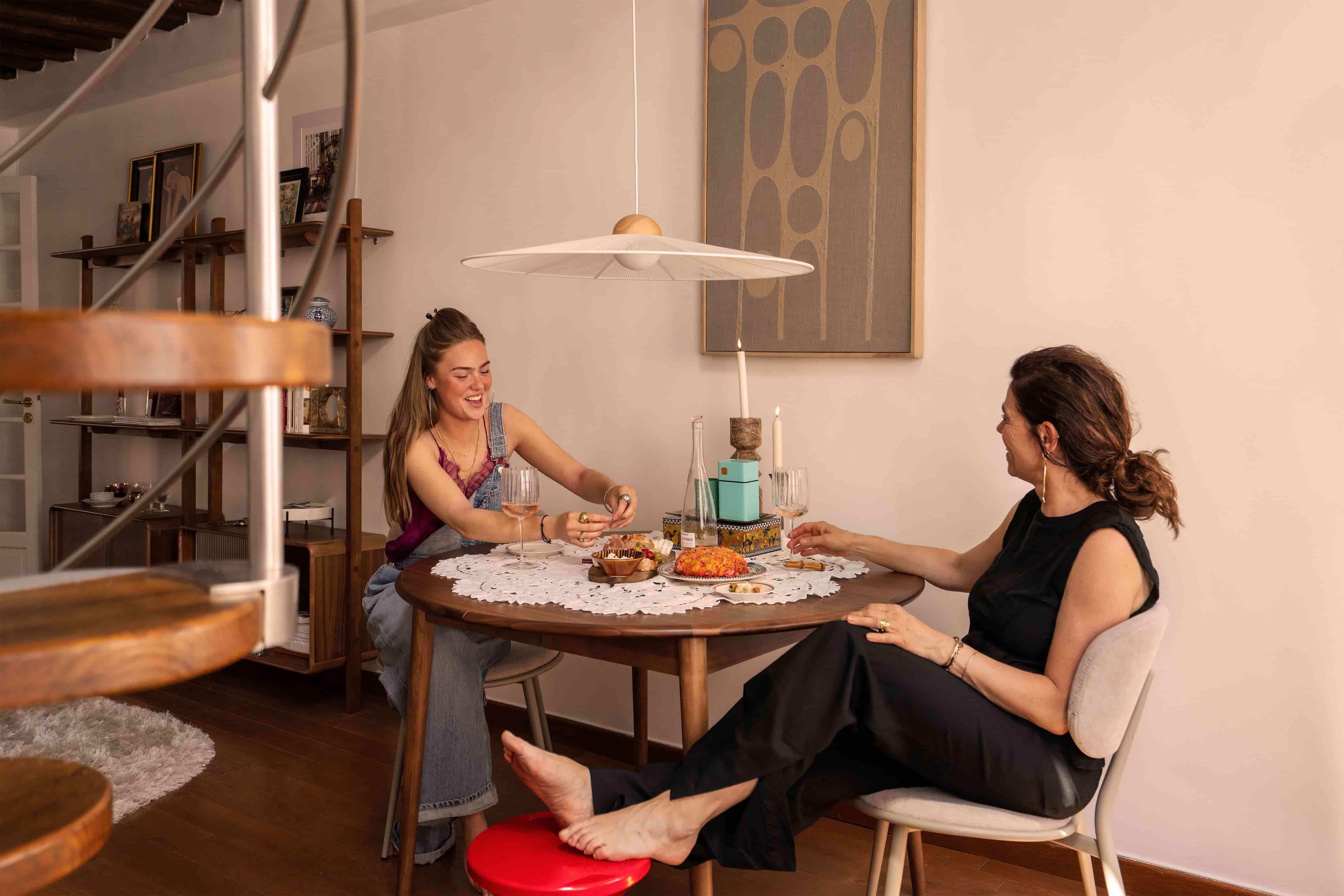 Dochter en moeder aan ronde eettafel in Parijse woning