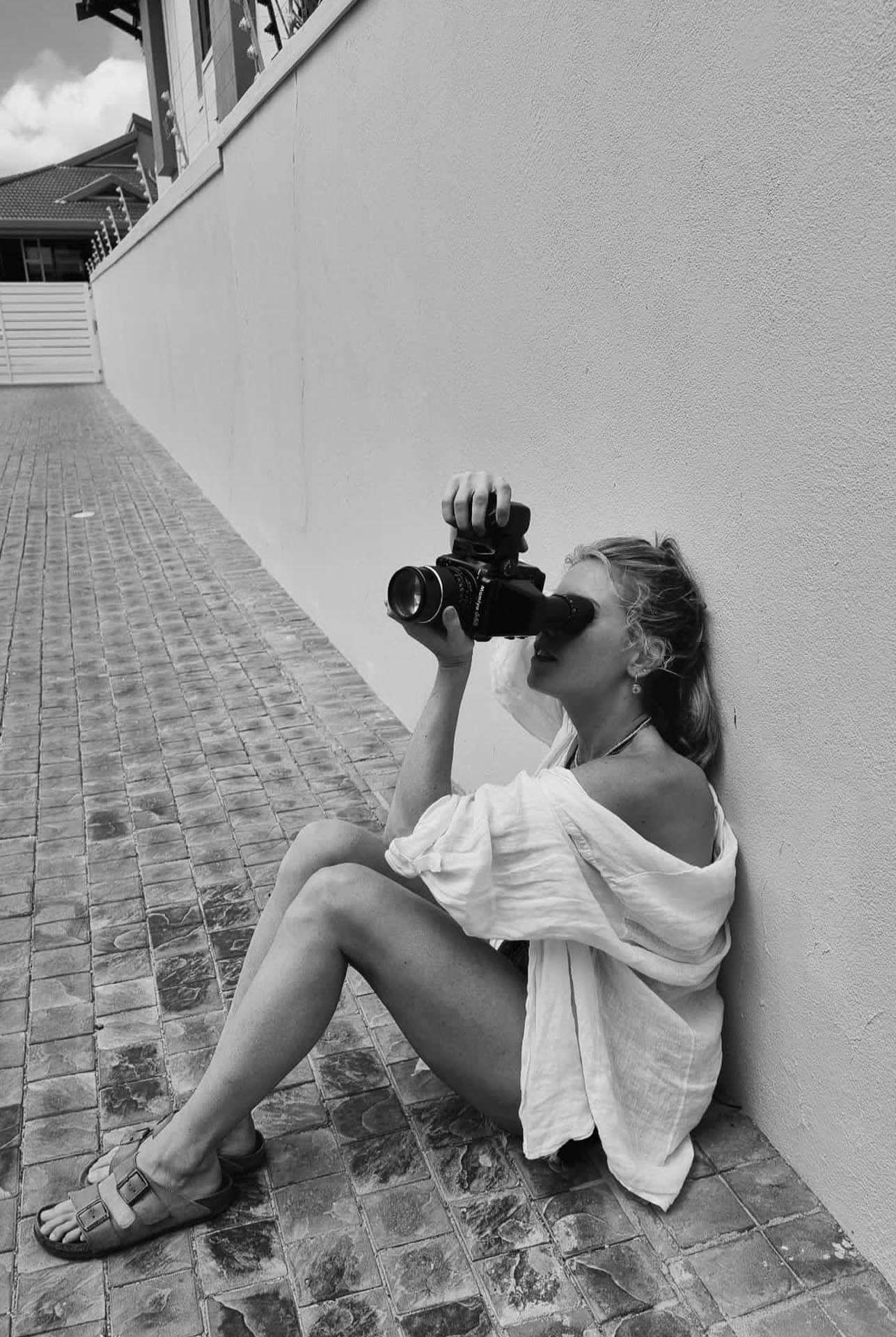 Caily Bobbie Jo zwart wit zittend op de grond met camera