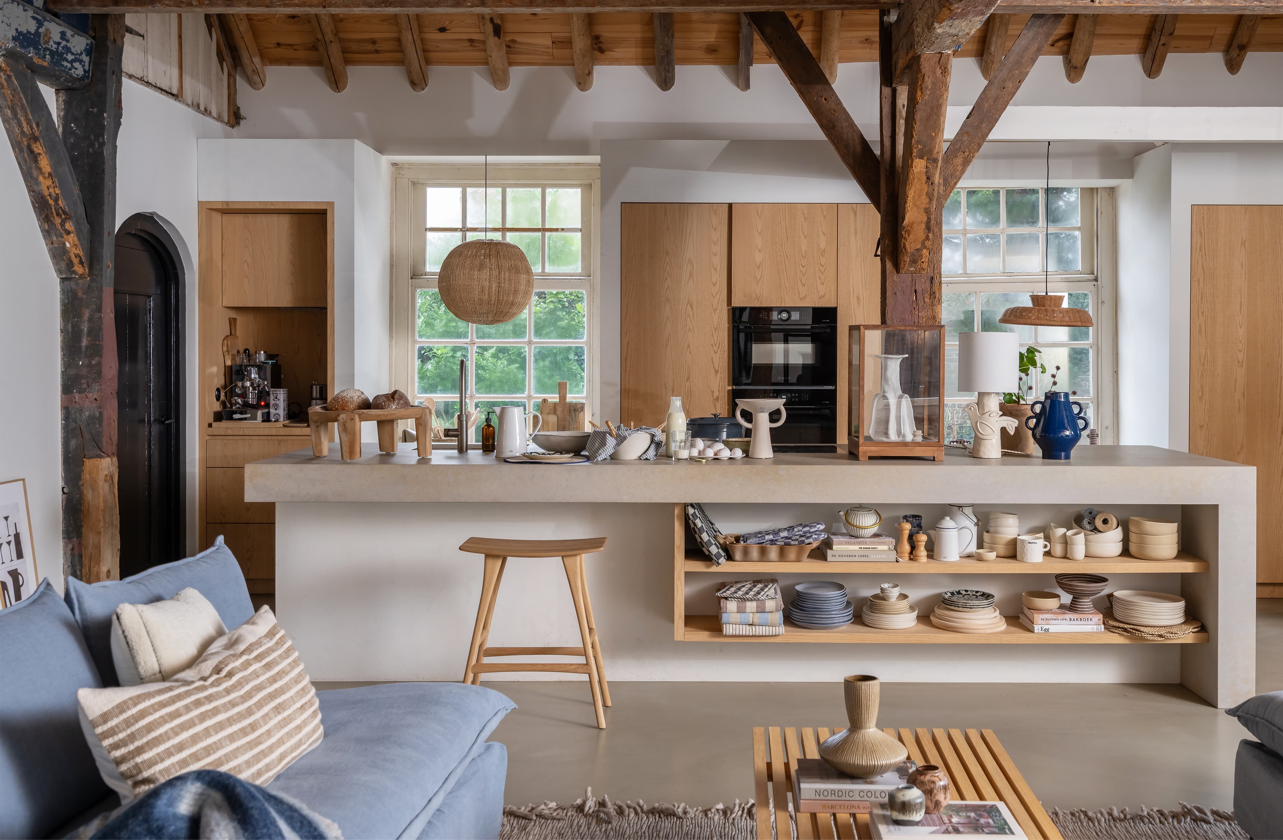 Groot robuust kookeiland in landelijke keuken met keramiek servies