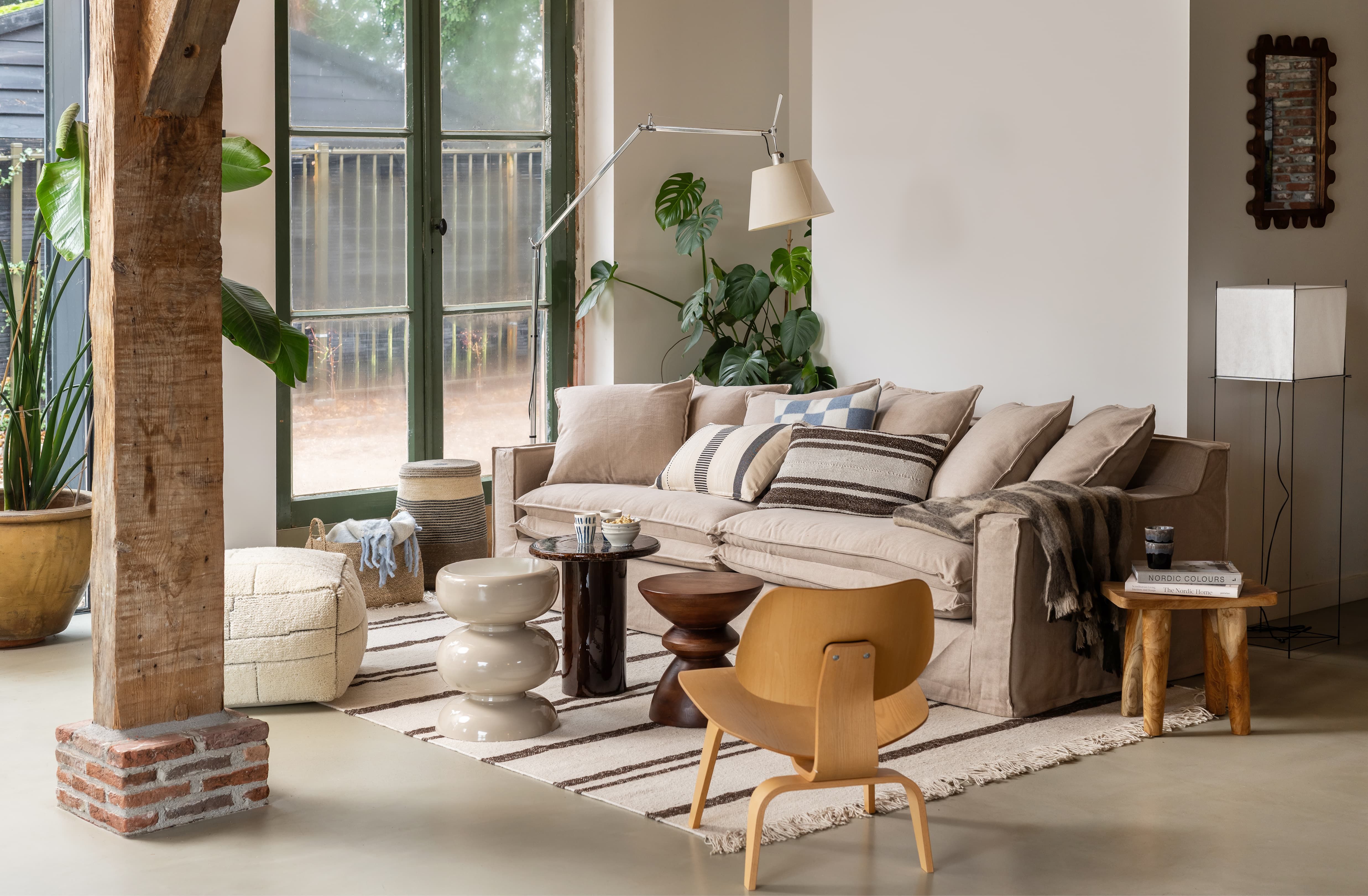 Lichte woonkamer met beige bank en gestreept vloerkleed