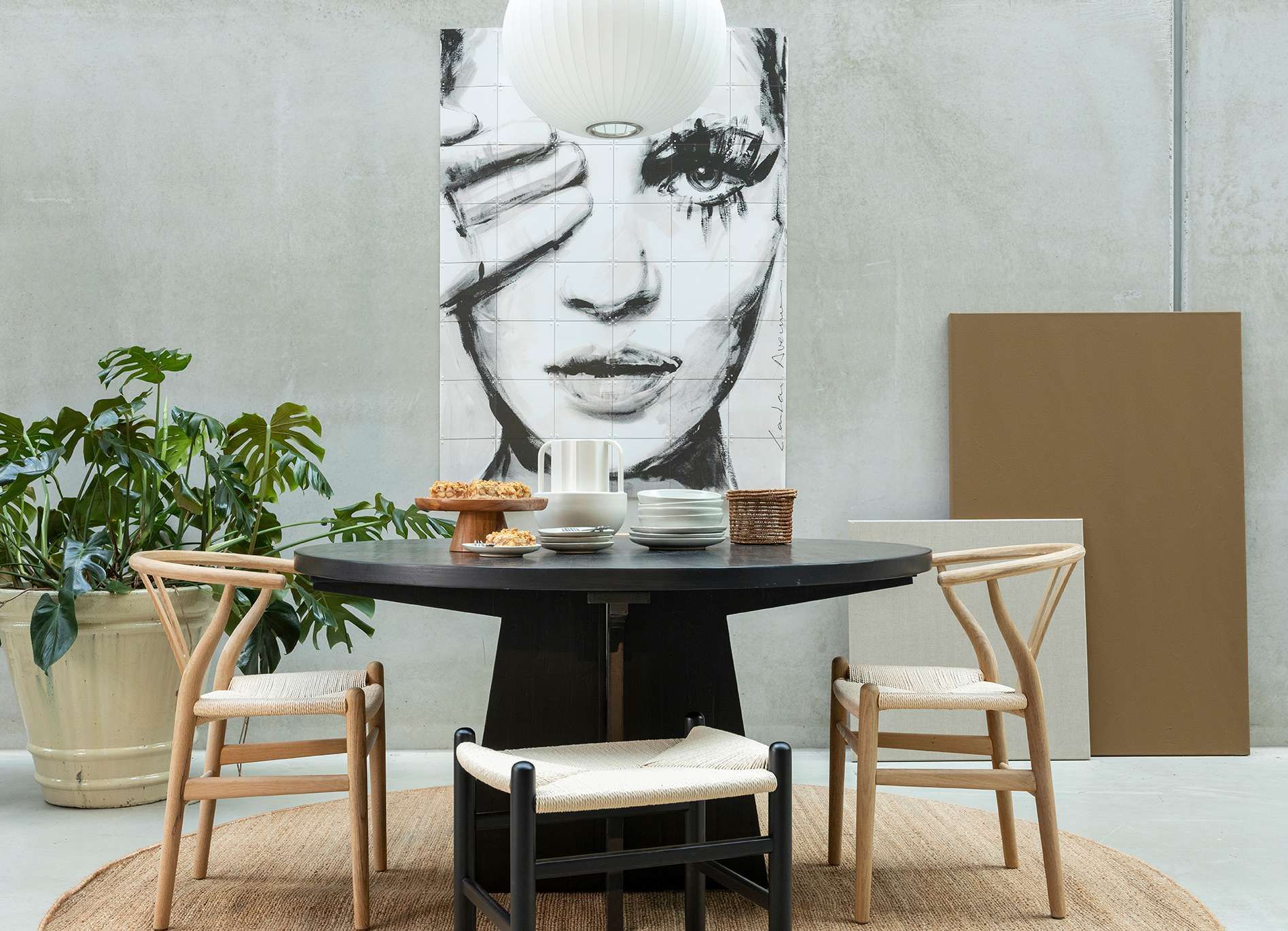 Eettafel met stoelen en daarachter IXXI wandkunst