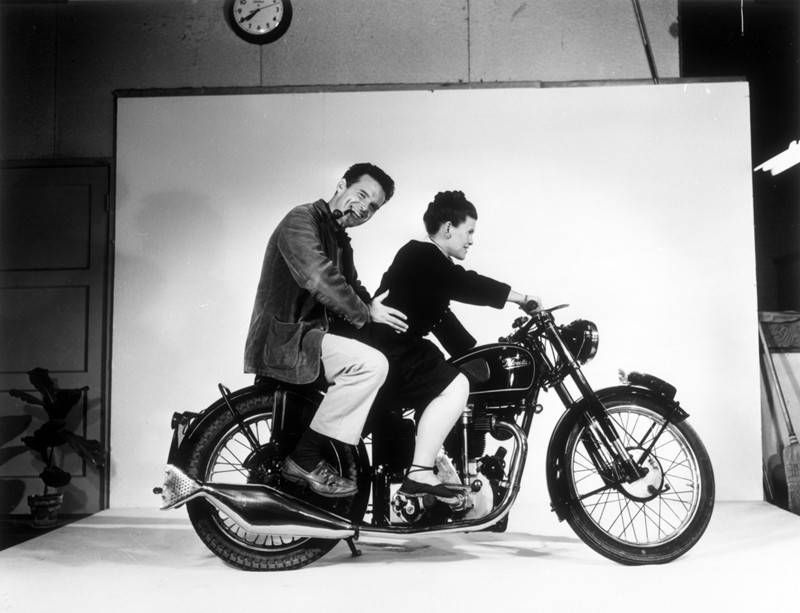 Charles en Ray Eames op een motor voor een wit fotoscherm