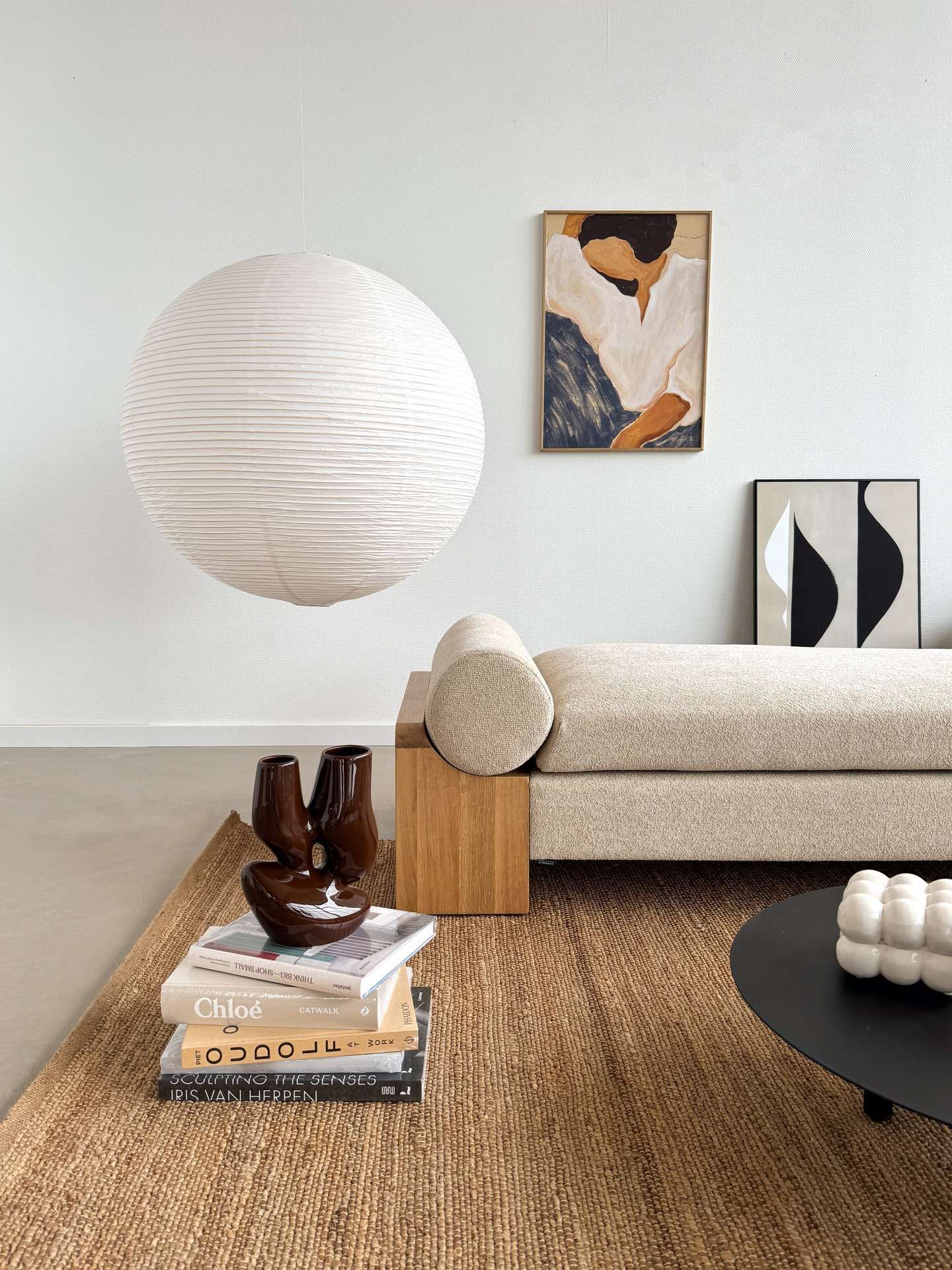 Witte ronde lamp met jute vloerkleed en hout daybed