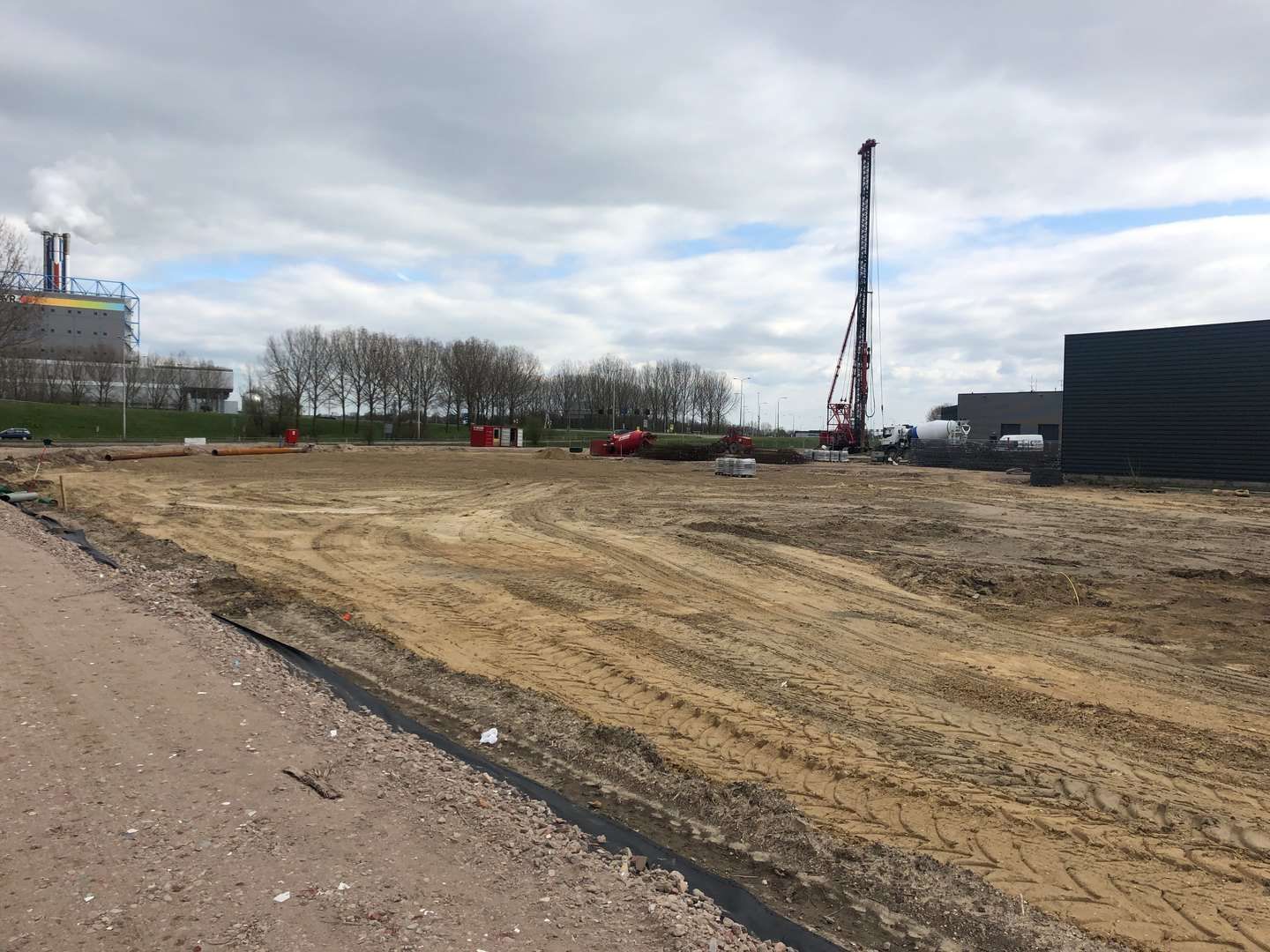 kaal stuk grond met heipaalmachine