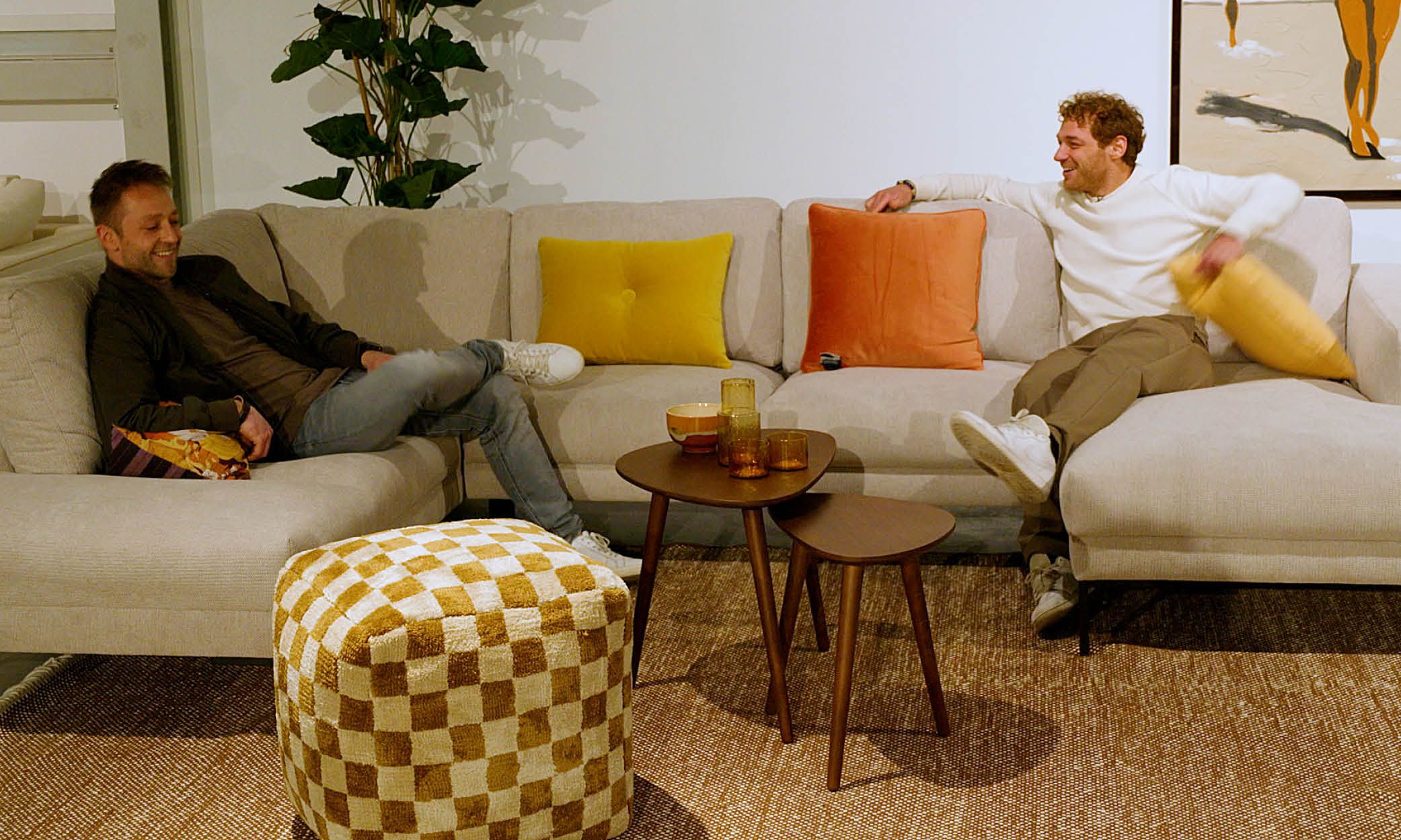 Dennis en Jamie zitten op een beige bank