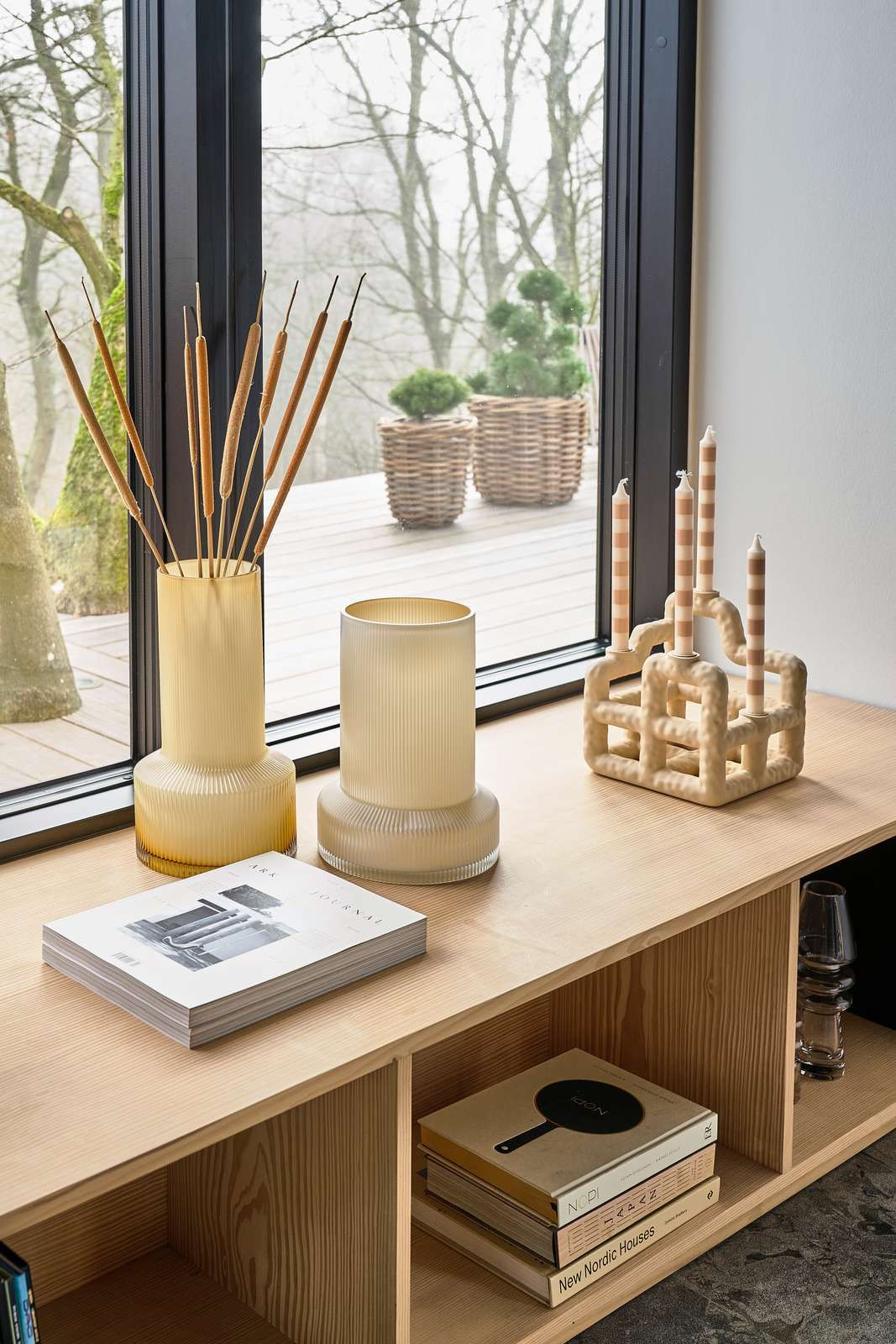 Eikenhouten meubel met lichtgekleurde vazen en boeken