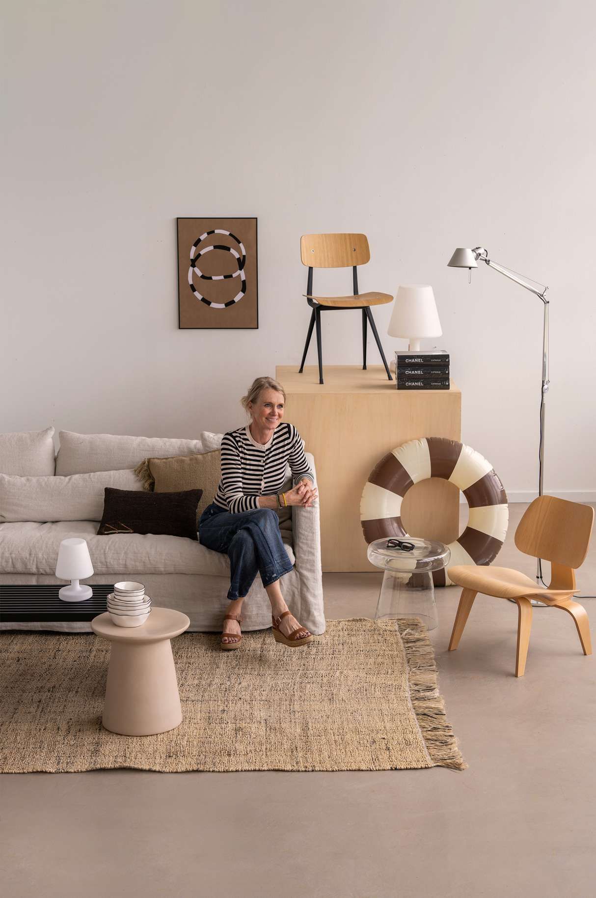 Vrouw in gestreept shirt tussen zomerse interieur items