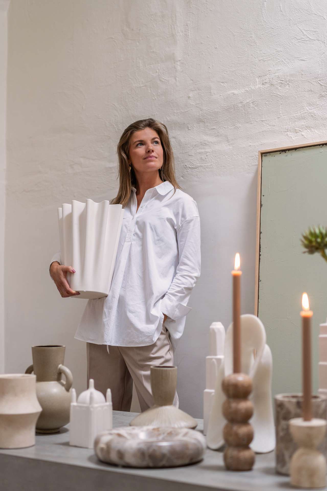 Vrouw die vaas vasthoud en accessoires op de voorgrond