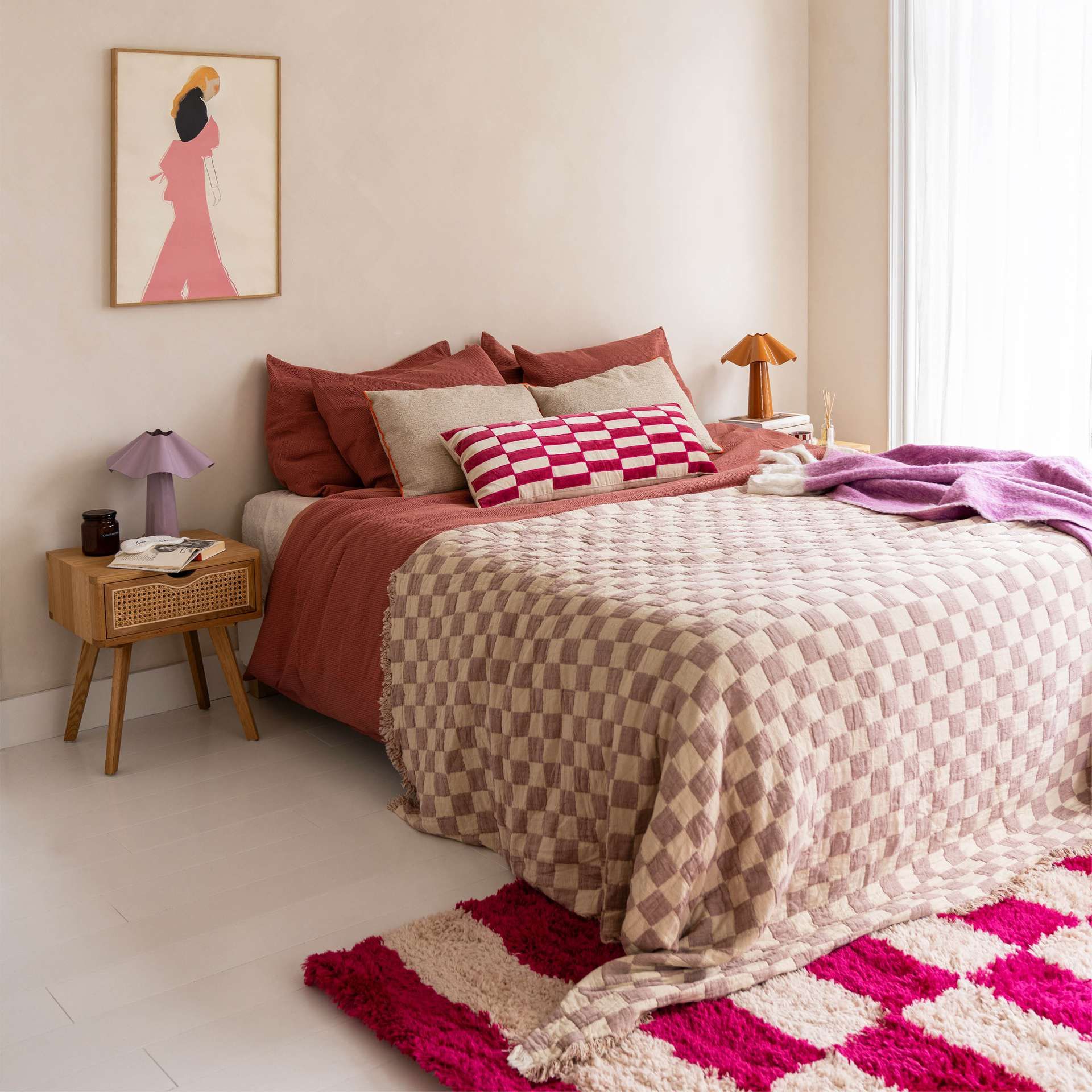 Strak opgemaakt bed met blokjes patroon sprei