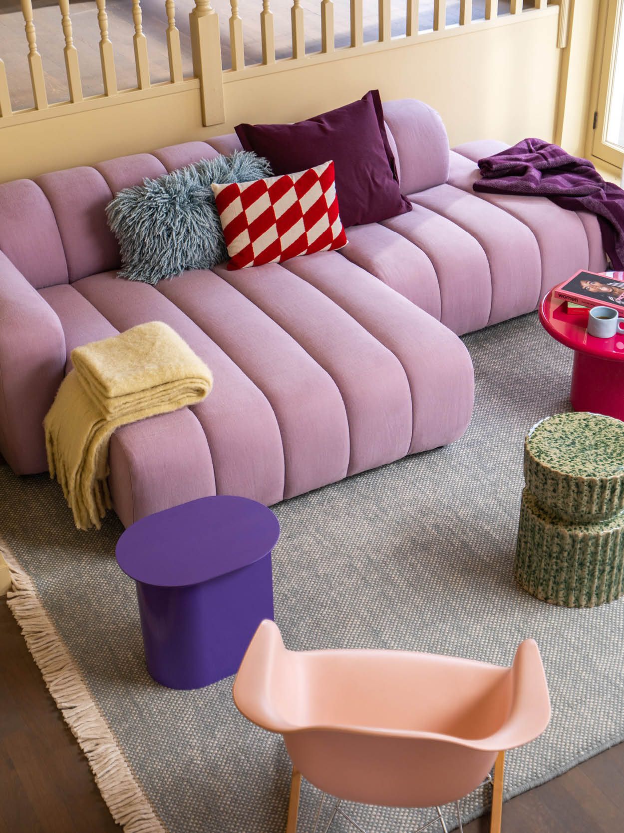 Woonkamer met lila bank en kleurrijke accessoires