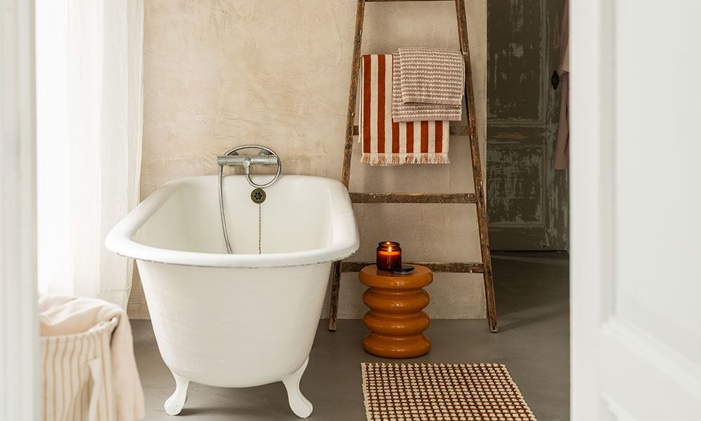 Wit bad in badkamer met gekleurd badtextiel