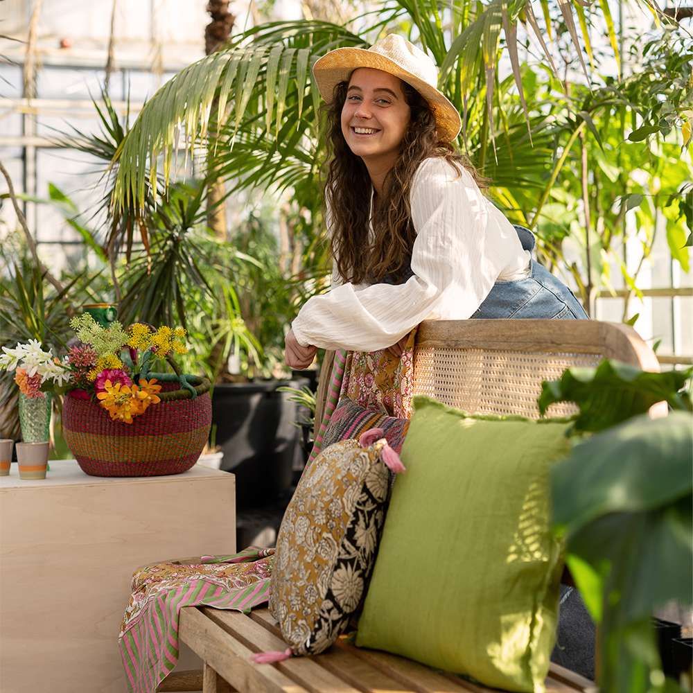 Stylist Lotte met hoed staat in groene omgeving