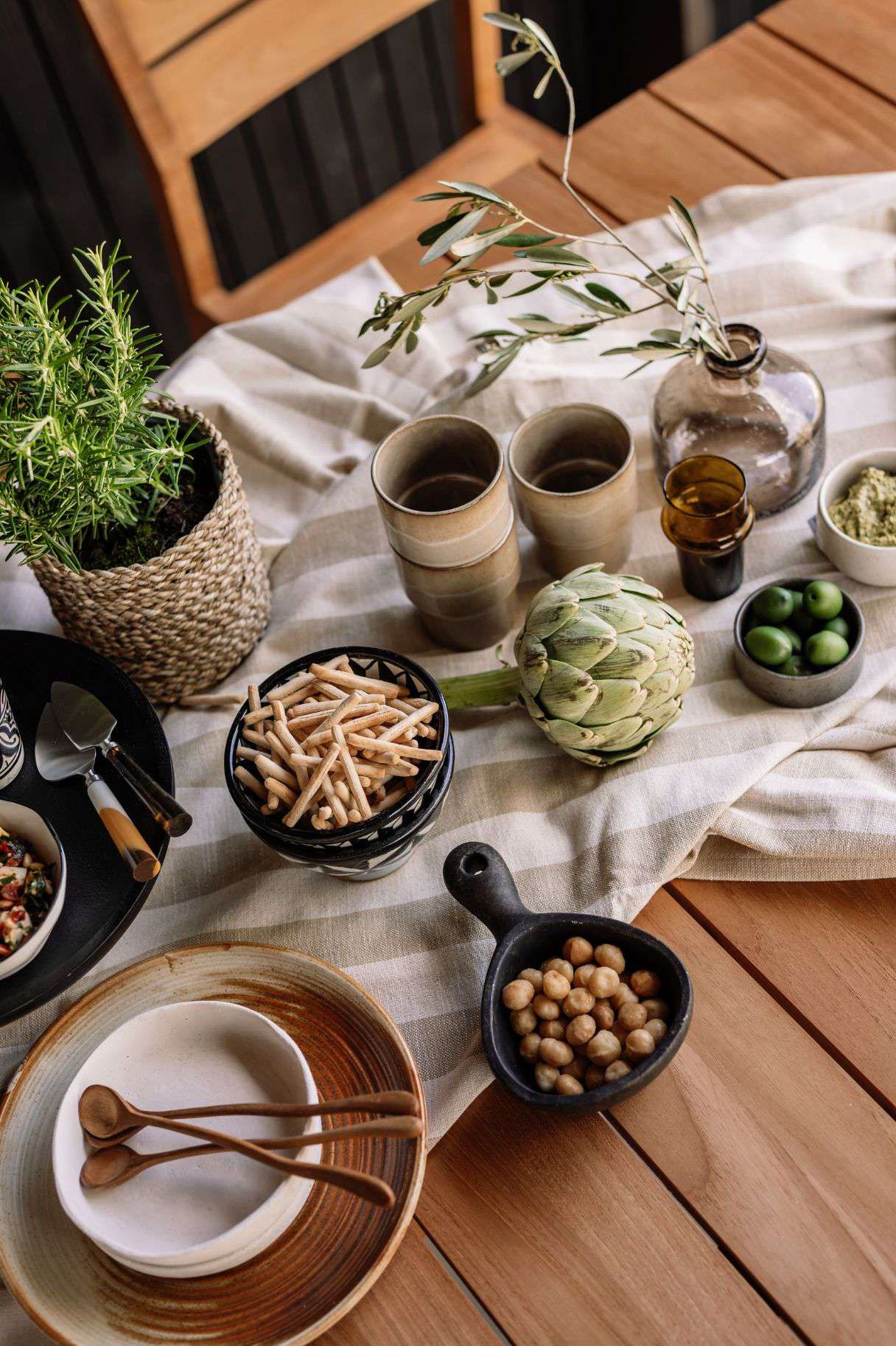 Tuintafel met gestreept beige tafelkleed met snacks