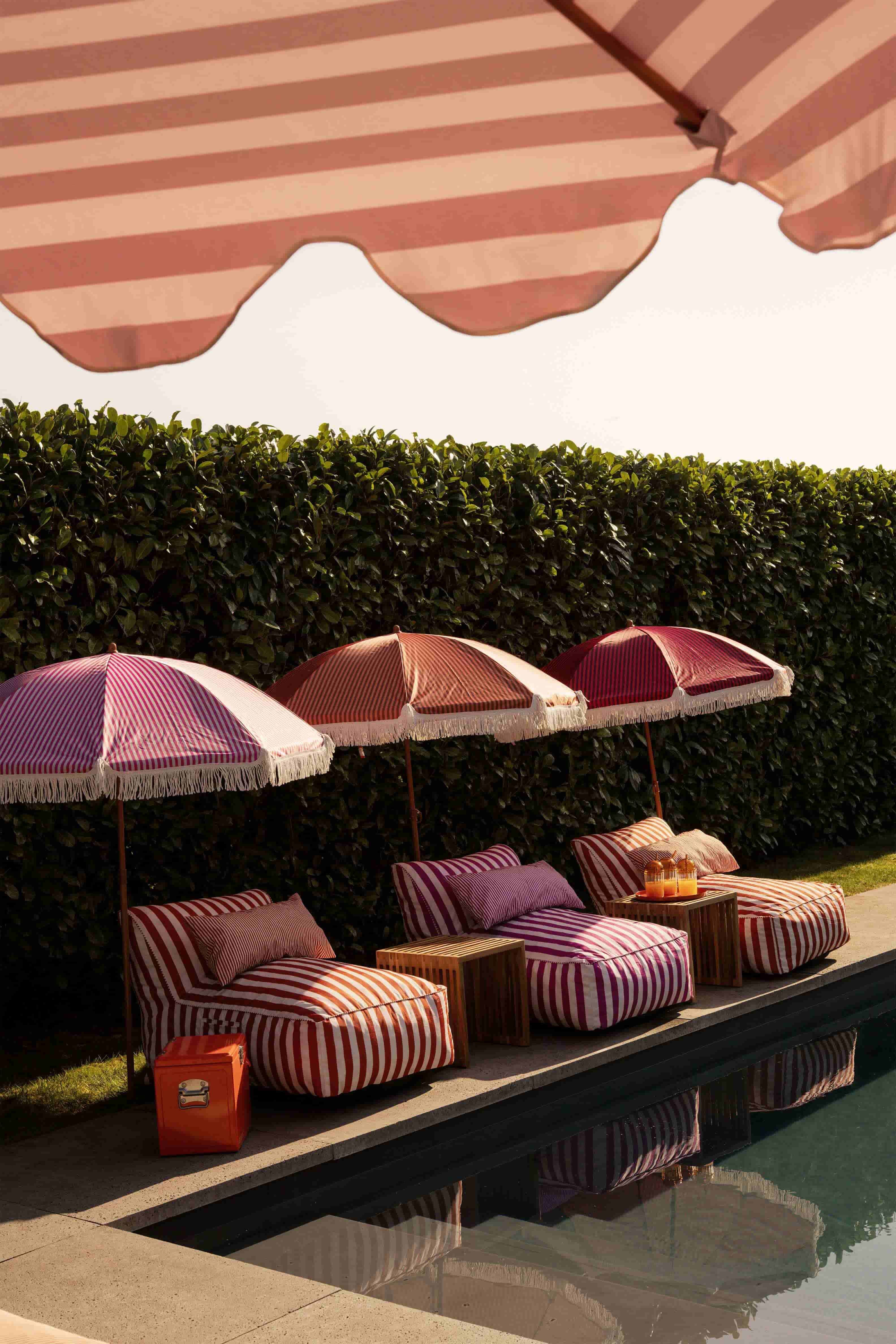 Zwembad met gestreepte ligbedden en parasols