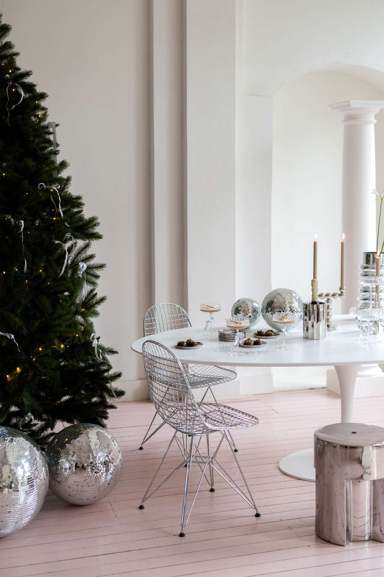 Feestelijke eethoek met witte tafel en zilveren stoelen met accessoires