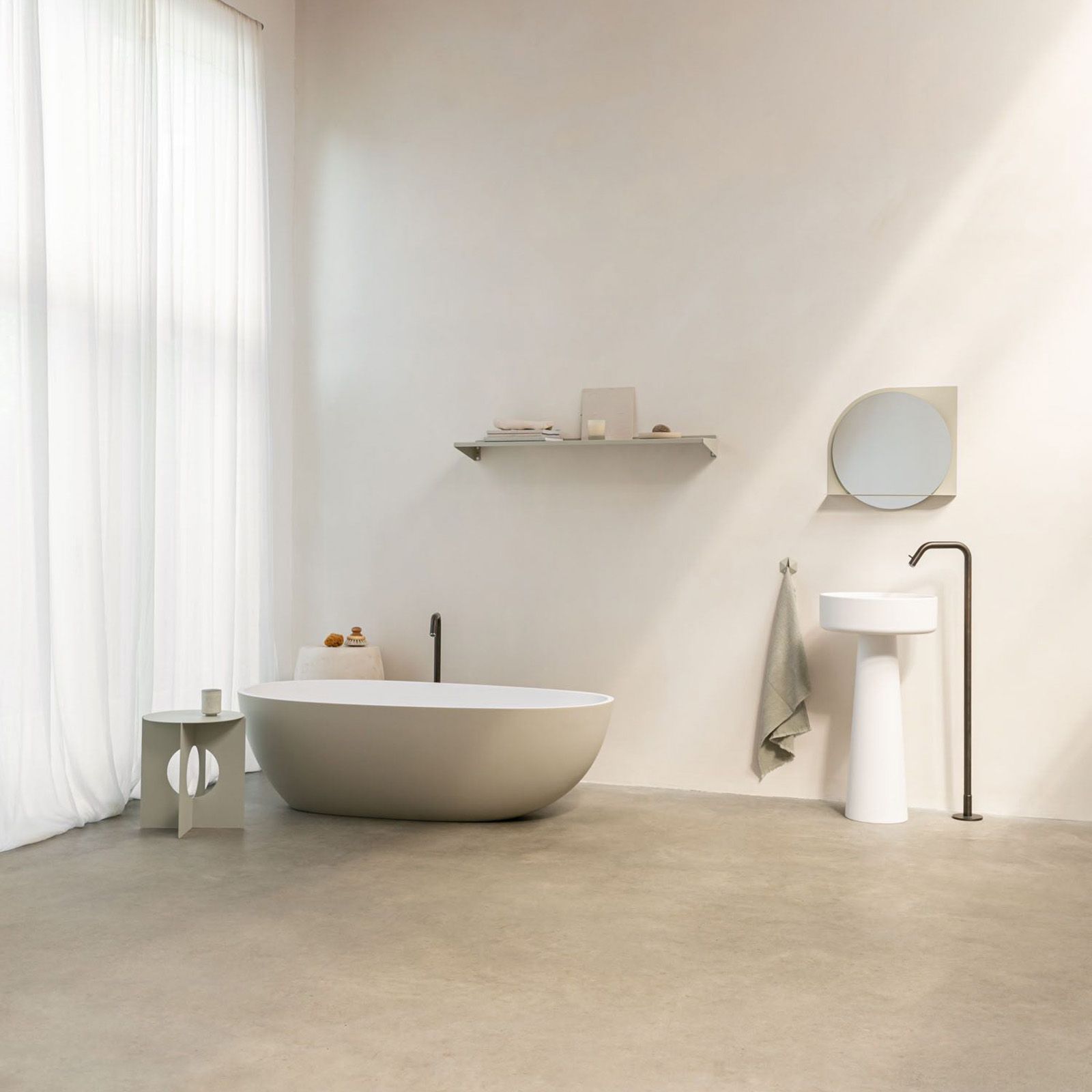 Lichte badkamer met gietvloer en wit bad