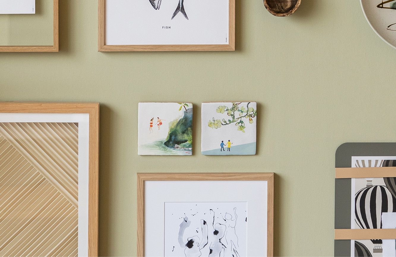 Groene muur met wandtegeltjes en kunst