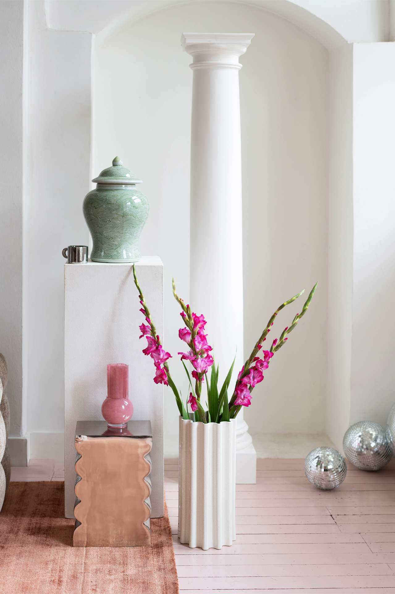 Hoge witte vaas en metallic bijzettafeltje witte muren