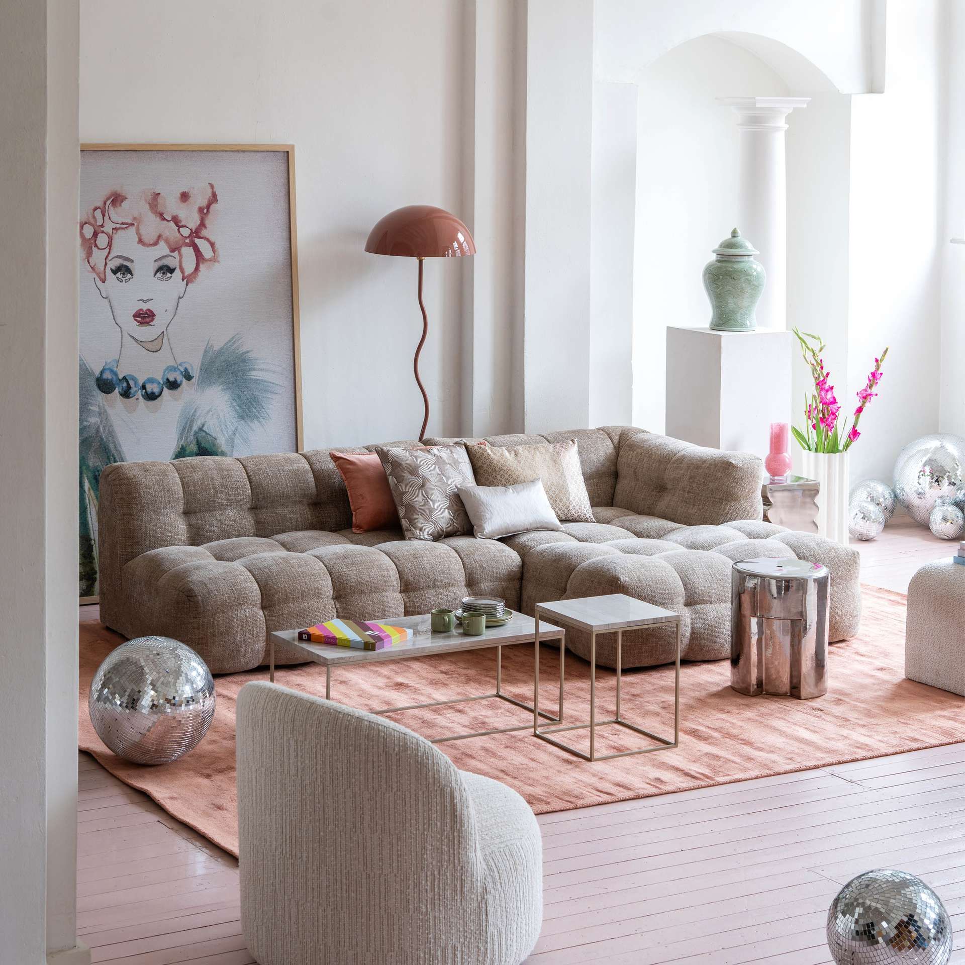 Woonkamer met beige Fat Joe hoekbank en roze accessoires