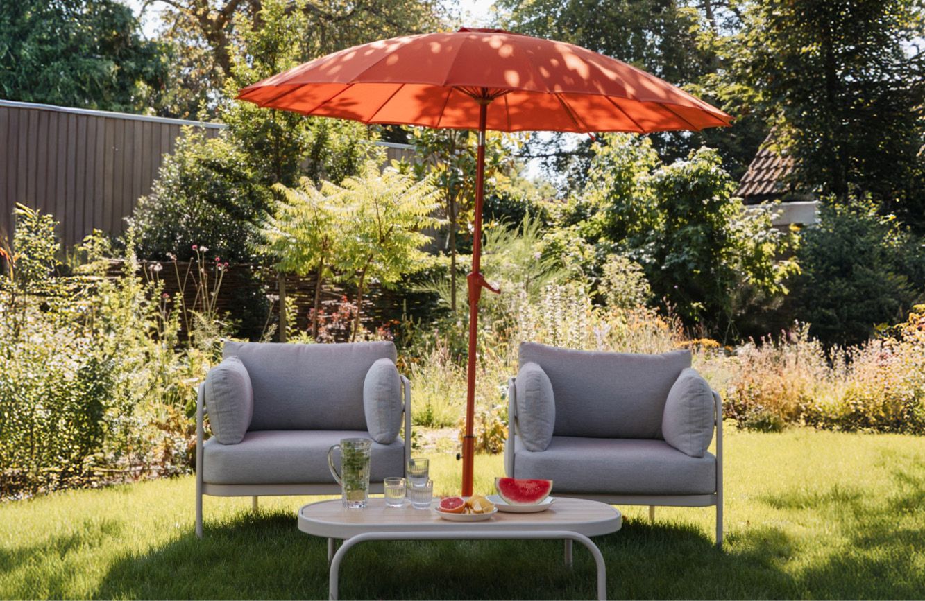 Buiten loungestoelen van zuiver met oranje parasol